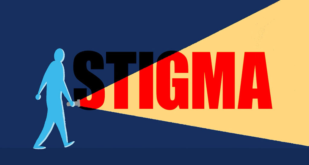 silhouette of a person with a flashlight signing a light to illuminate the word "stigma"