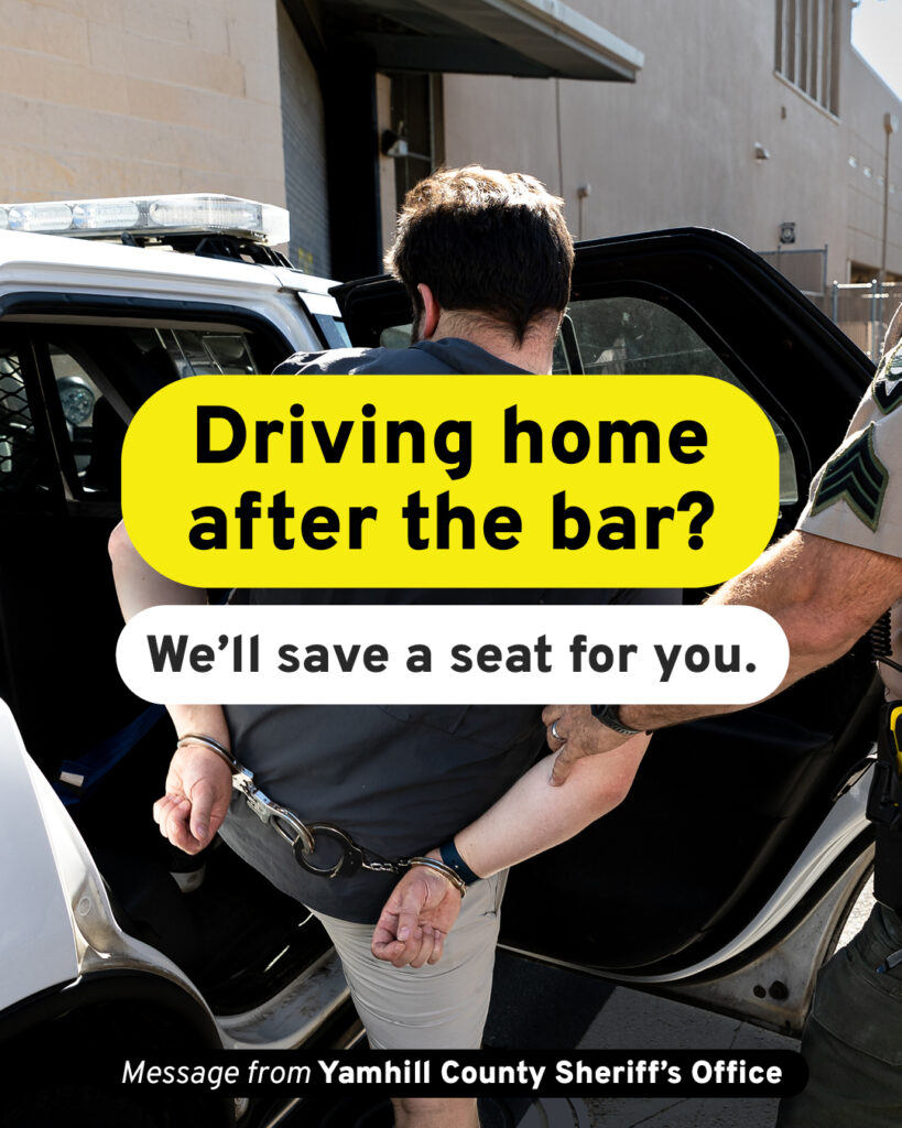 Picture of a person from behind. They are handcuffed and being helped into the back of a Yamhill County Sheriff car. Text is overlaid on the image and reads - Driving home after the bar? We'll save a seat for you. Smaller text reads, Message from Yamhill County Sheriff's Office.