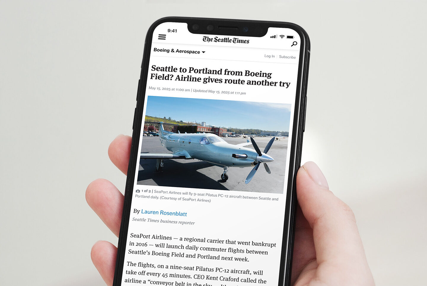 Hand holding phone with a Seattle Times article about SeaPort Airlines
